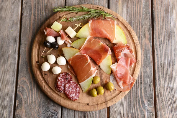 Delicious melon with prosciutto on table close-up — Stock Photo, Image