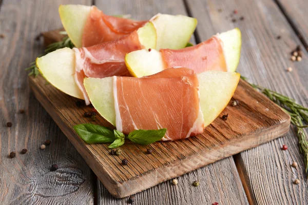 Delicious melon with prosciutto on table close-up — Stock Photo, Image