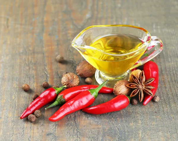 Homemade natural infused olive oil with red chili peppers and spices  on  wooden background — Stock Photo, Image