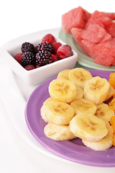 Slices of fruits with berries on plate close up — Stock Photo, Image