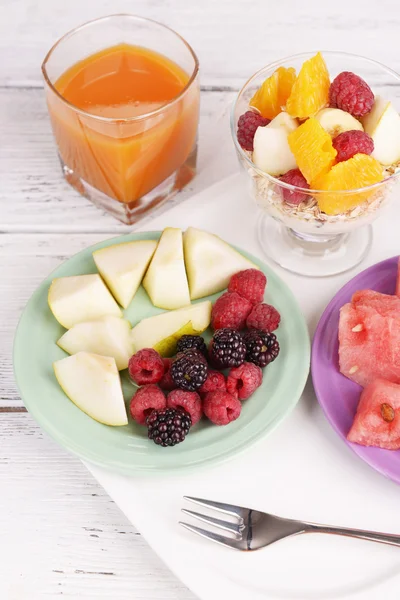 Fatias de frutas com bagas e muesli na mesa de madeira — Fotografia de Stock