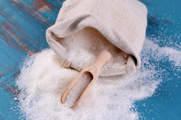 Açúcar no saco na cor de fundo de madeira — Fotografia de Stock