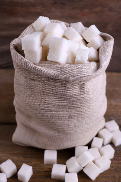 Refined sugar in bag on wooden background — Stock Photo, Image