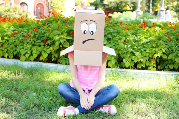 Mujer con caja de cartón en la cabeza con cara triste, al aire libre —  Fotos de Stock