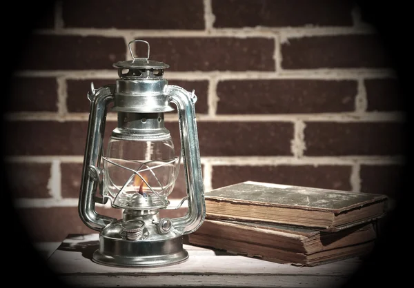 燃烧的煤油灯和书籍 — 图库照片