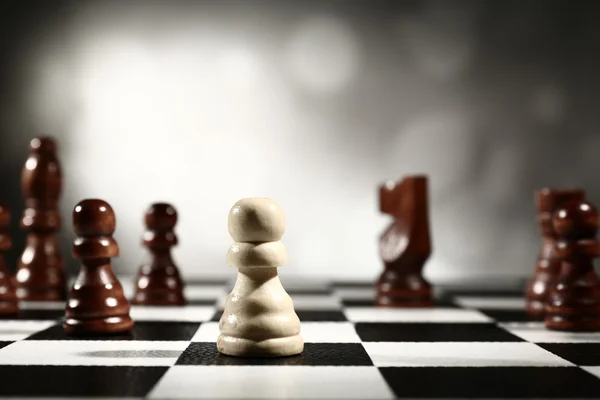 Chess board with chess pieces on grey background — Stock Photo, Image