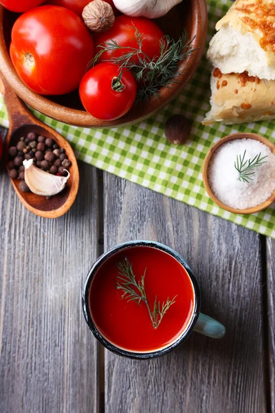 Sumo de tomate caseiro na caneca a cores, pães, especiarias e tomates frescos no fundo de madeira — Fotografia de Stock