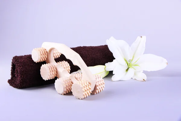 Wooden roller brush, towels and lily on grey background — Stock Photo, Image
