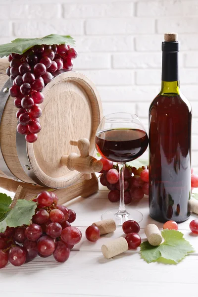 Vinho com uvas na mesa no fundo da parede de tijolo — Fotografia de Stock