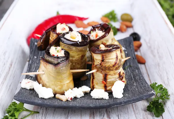 Gebakken aubergine met cottage kaas in een vierkant bord op houten achtergrond — Stockfoto