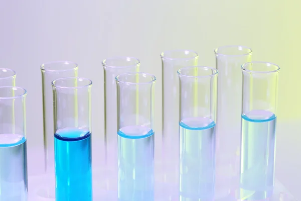 Test-tubes with blue liquid on lilac background — Stock Photo, Image