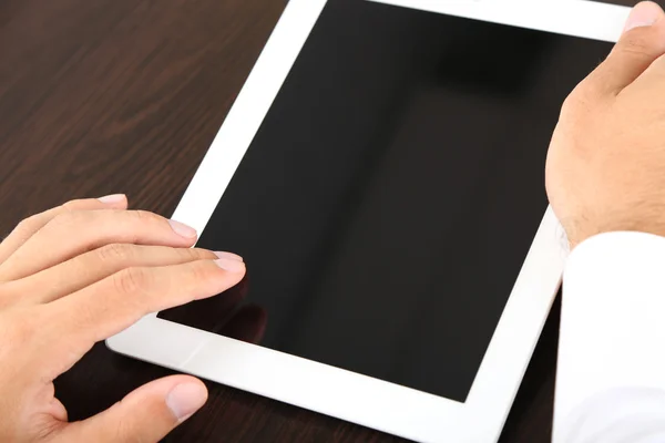 Člověk pracuje na tabletu na dřevěné pozadí closeup — Stock fotografie