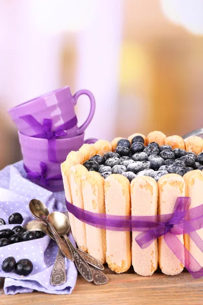 Tasty cake Charlotte with blueberries on wooden table, on light background — Stock Photo, Image