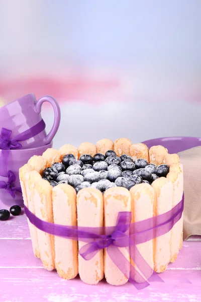 Tasty cake Charlotte with blueberries on wooden table, on light background — Stock Photo, Image