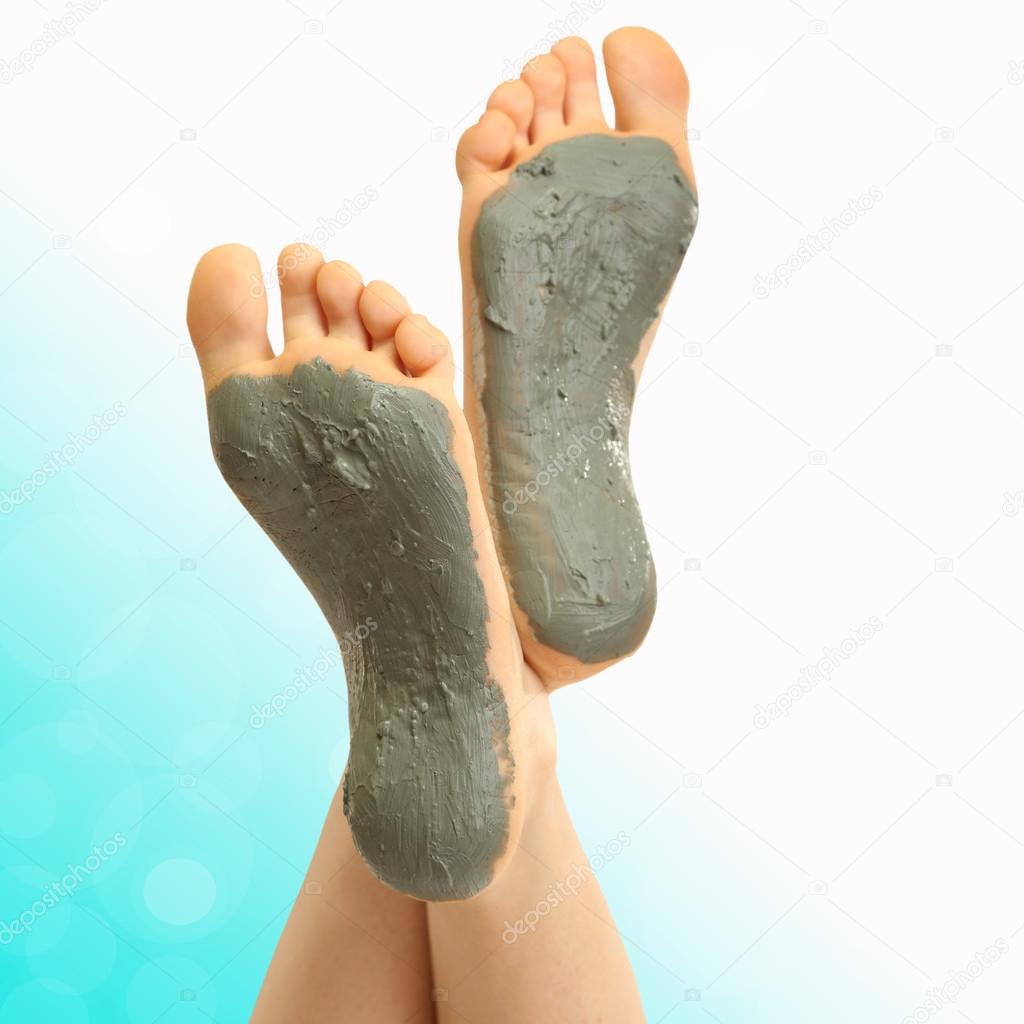Woman foots with cosmetic clay