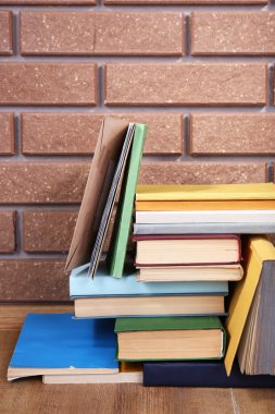 ahşap masa tuğla duvar zemin üzerine kitaplar