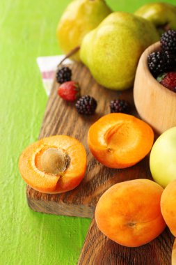 Olgunlaşmış meyve ve çilek kase masa üzerinde kapat