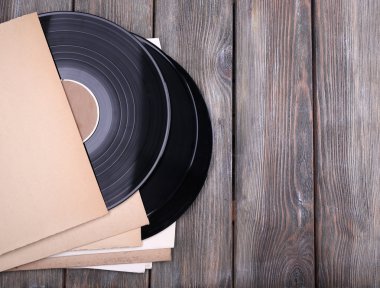 vinil kayıtları ve kağıt kapakları ahşap zemin üzerinde