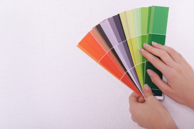 Duvarın rengini odadaki kumaşlardan seçen kadın