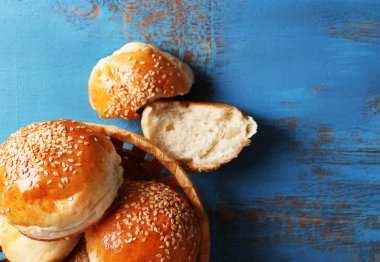 renkli ahşap zemin üzerinde hasır sepet içinde susam ile lezzetli çörekler