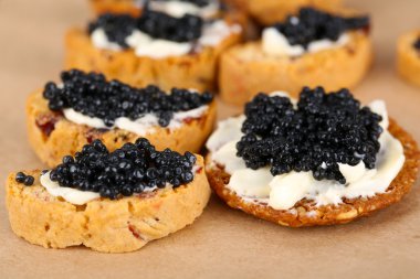 Kağıt arka plan üzerinde siyah havyar ve tereyağı ile ekmek dilimleri