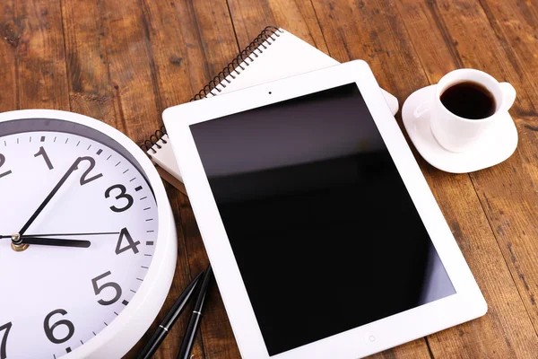 Tableta, taza de café, cuaderno y reloj sobre fondo de madera — Foto de Stock