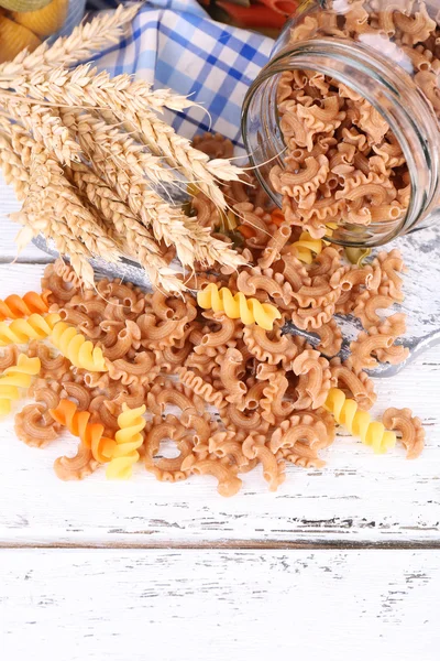 Pastas coloridas en frascos de vidrio sobre fondo de madera —  Fotos de Stock