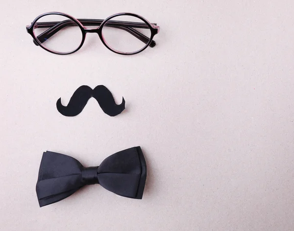 Lunettes, moustache et noeud papillon formant visage d'homme sur fond de couleur — Photo