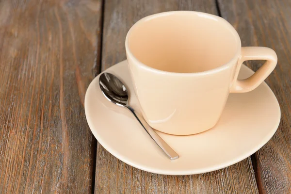 Tazza vuota con cucchiaino da tè su sfondo di legno — Foto Stock