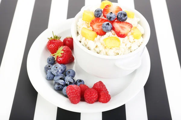 El requesón con las frutas y las bayas en la escudilla a la mesa — Foto de Stock