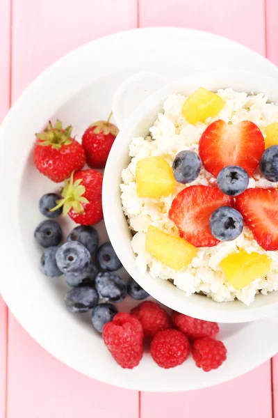 Cottage cheese with fruits and berries in bowl on wooden table — Stock Photo, Image