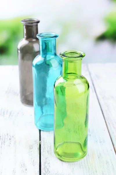 Botellas de vidrio vacías en la mesa sobre fondo brillante — Foto de Stock