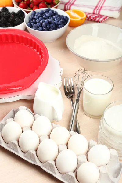 Lekkere taart en ingrediënten bakken voor het op tafel in de keuken — Stockfoto