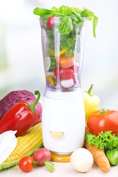 Blender with fresh vegetables on kitchen table — Stock Photo, Image