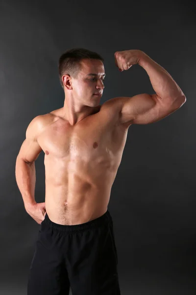 Hombre joven musculoso guapo sobre fondo oscuro — Foto de Stock