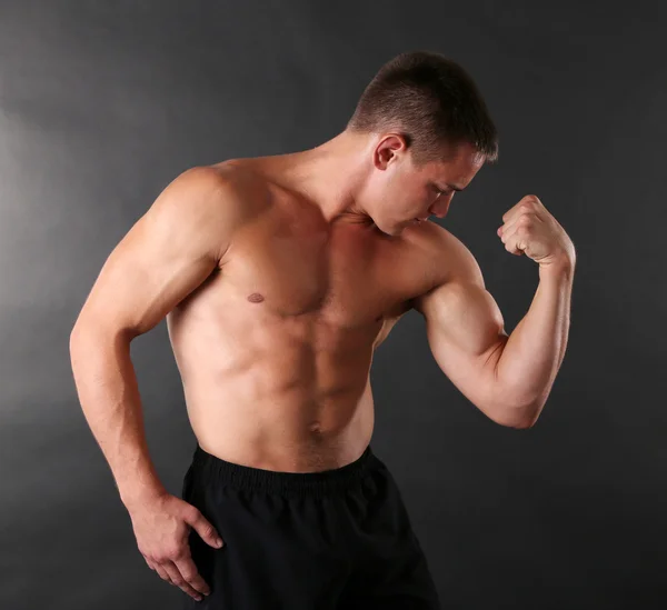 Handsome muscle young man on dark background — Stock Photo, Image