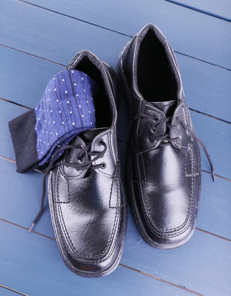 Μαύρα Ανδρικά παπούτσια και κάλτσες σε σκούρο μπλε φόντο ξύλινα — Φωτογραφία Αρχείου