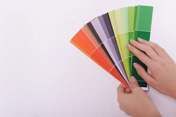 Woman choosing color for wall from swatches in room — Stock Photo, Image