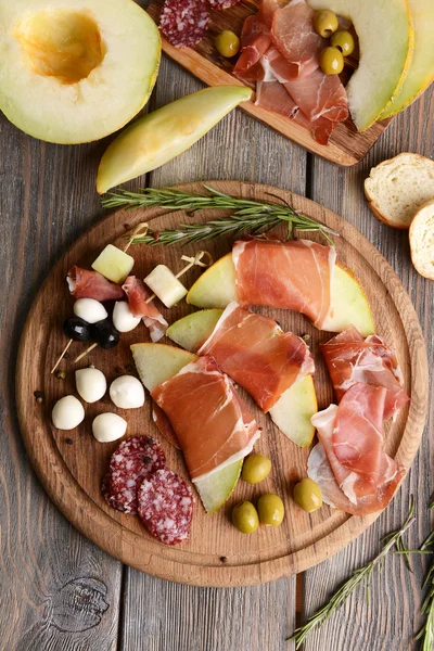 Delicious melon with prosciutto on table close-up — Stock Photo, Image