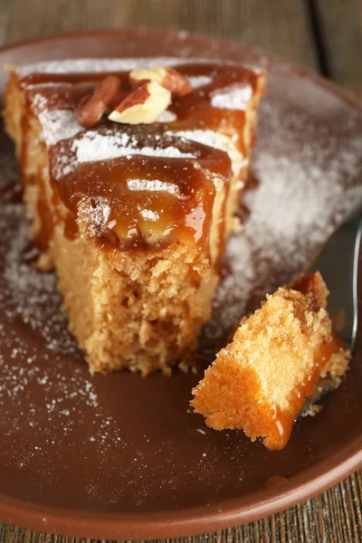 Metade comeu deliciosa peça de bolo na placa na mesa de madeira — Fotografia de Stock