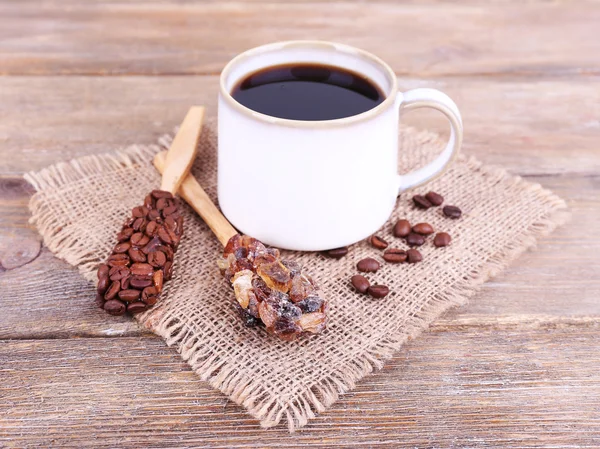 Mugg kaffe på säckväv på trä bakgrund — Stock fotografie