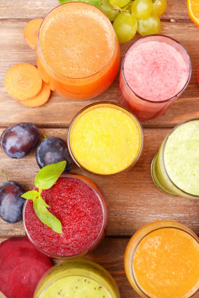 Glasses of tasty fresh juice, on wooden table. — Stock Photo, Image