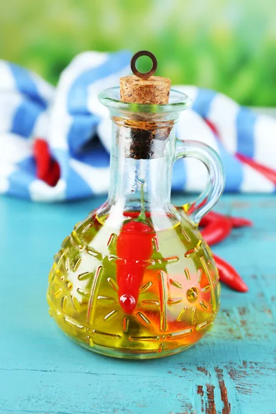 Hemmagjord naturlig infunderas olja med röd chilipeppar i flaska på färg trä bakgrund — Stockfoto