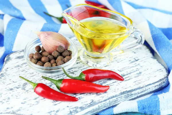 Ensemble d'épices et d'huile d'olive en saucière en verre, en planche à découper, sur fond de bois de couleur — Photo