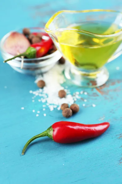 Набор специй и оливкового масла в стеклянной соус-лодке, на цветном деревянном фоне — стоковое фото