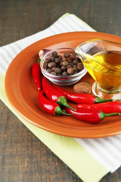 Набор специй и оливкового масла на тарелке, на деревянном фоне — стоковое фото