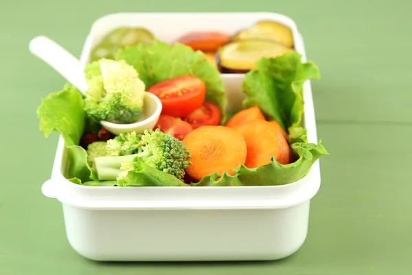 God vegetarisk mat i plastlåda på gröna träbord — Stockfoto