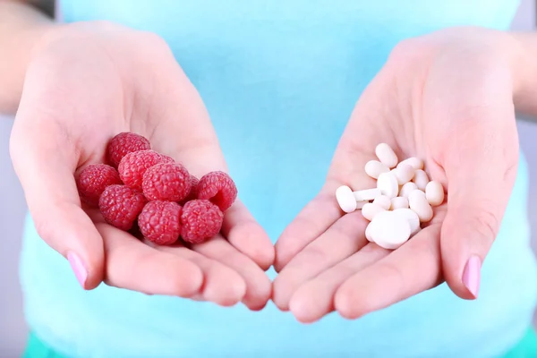 Frau im Besitz von Beeren und Pillen — Stockfoto