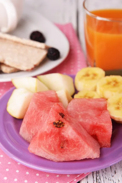 Fette di frutta con pane croccante e bicchiere di succo sul tavolo da vicino — Foto Stock