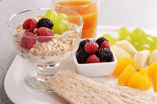 Slices of fruits with berries and muesli on table close up — Stock Photo, Image